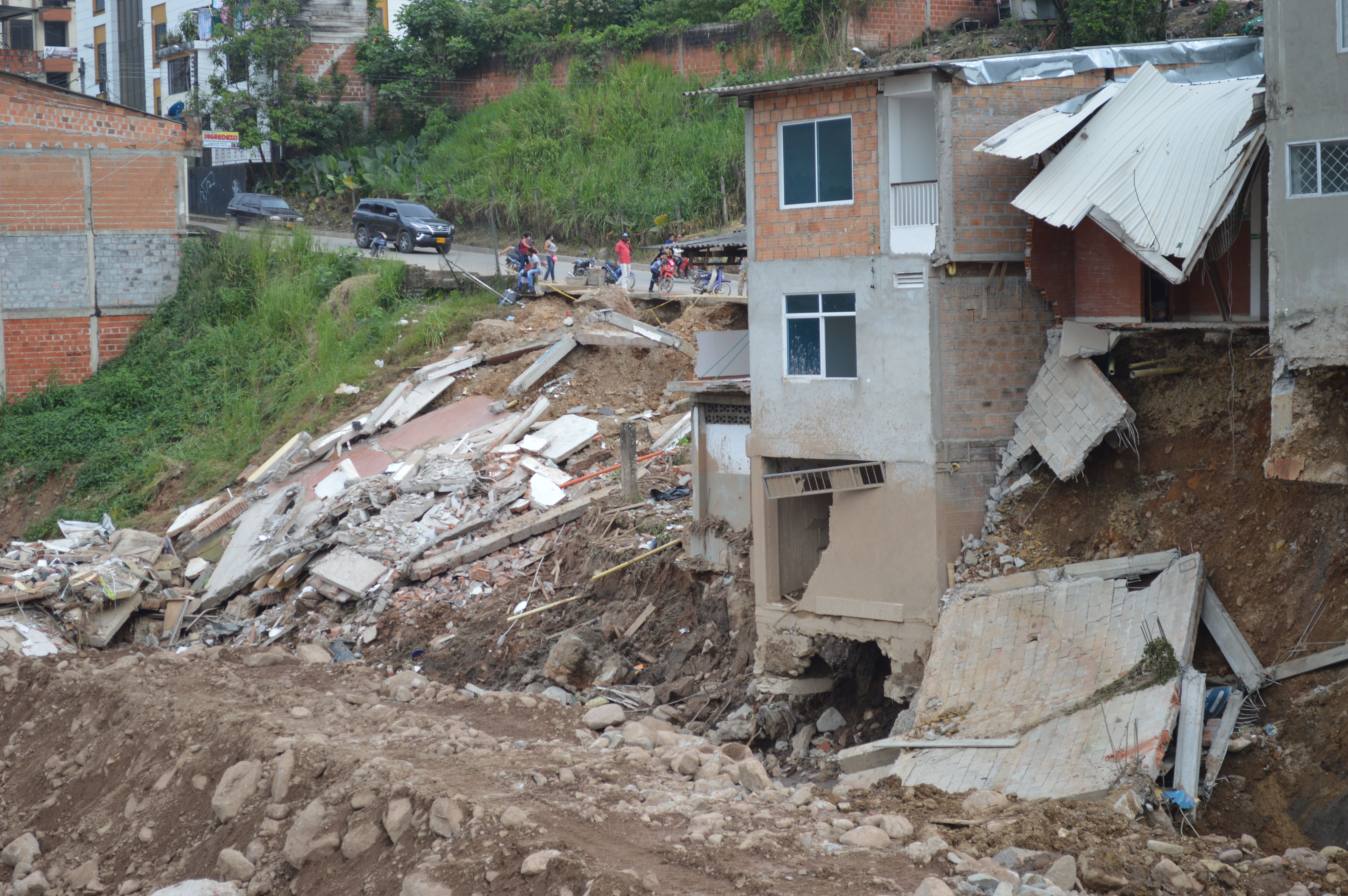 Especialistas defendem cultura da prevenção para a redução de desastres Casas atingidas por deslizamento de terra em encosta